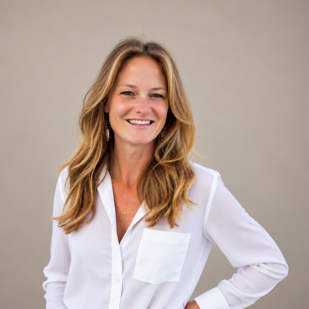 Elizabeth Arnold smiling in a white blouse against a neutral background
